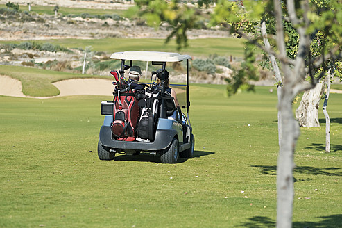 Cyprus, Man and woman sitting in golf cart - GNF001219