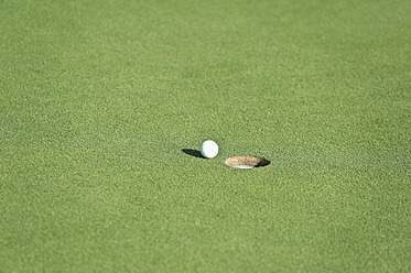 Cyprus, Golf ball by hole on golf course - GNF001209