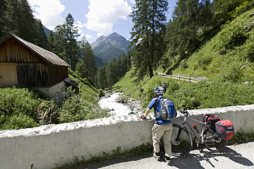 Schweiz, Älterer Mann stehend mit Fahrrad - DSF000439