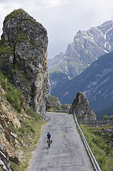 Schweiz, Älterer Mann fährt mit dem Fahrrad durch eine Bergstraße - DSF000402