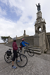 Spanien, Mallorca, Mann und Frau mit Fahrrad, Blick auf Santuari de Sant Salvador - DSF000441