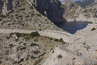 Spanien, Mallorca, Mann und Frau beim Radfahren auf der Straße am Cap de Formento - DSF000413