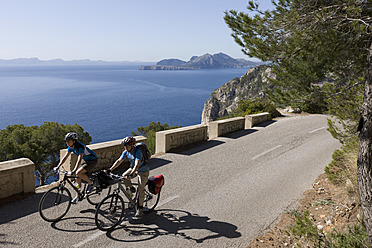 Spanien, Mallorca, Mann und Frau beim Radfahren auf der Straße am Cap de Formento - DSF000416