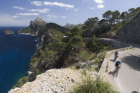 Spanien, Mallorca, Mann und Frau beim Radfahren auf der Straße am Cap de Formento - DSF000418