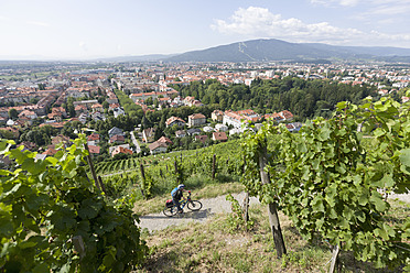 Slowenien, Maribor, Älterer Mann radelt durch Weinberg - DSF000425