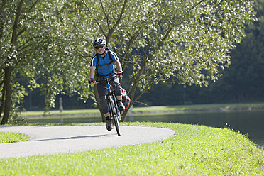 Österreich, Älterer Mann fährt Fahrrad am Stubenbergsee - DSF000436