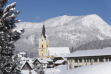 Österreich, Steiermark, Bad Mittendorfer Kirchturm mit schneebedecktem Berg im Hintergrund - SIEF002514