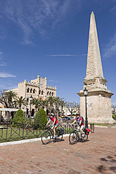 Spain, Menorca, Man and woman cycling through Ciutadella - DSF000522