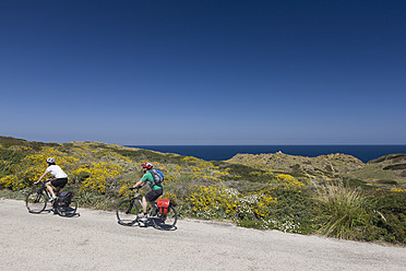 Spanien, Menorca, Mann und Frau beim Radfahren am Meer - DSF000519