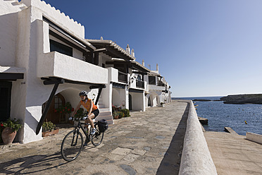 Spanien, Menorca, Binibeca, Frau radelt über Promenade - DSF000496