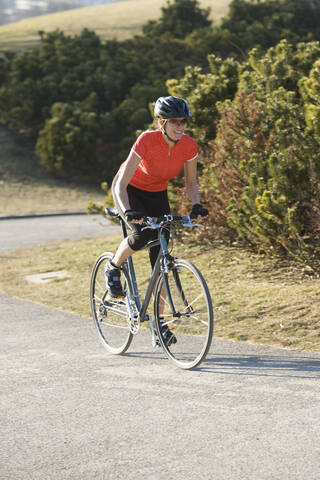 Deutschland, Bayern, München, Mittlere erwachsene Frau fährt Fahrrad, lizenzfreies Stockfoto