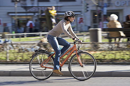 Deutschland, Bayern, München, Mittlere erwachsene Frau fährt Fahrrad - DSF000478