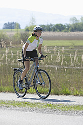 Deutschland, Bayern, Mittlere erwachsene Frau fährt Fahrrad - DSF000474
