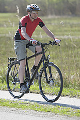 Deutschland, Bayern, Älterer Mann fährt Fahrrad - DSF000473