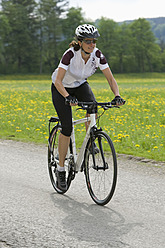 Germany, Bavaria, Mid adult woman riding bicycle - DSF000469