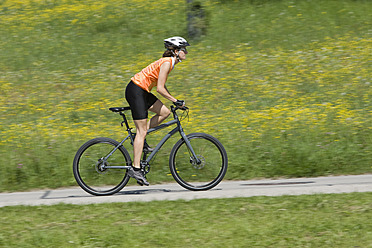 Deutschland, Bayern, Mittlere erwachsene Frau fährt Fahrrad - DSF000467