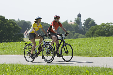 Deutschland, Bayern, Mann und Frau fahren Fahrrad - DSF000466