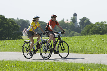 Germany, Bavaria, Man and woman riding bicycle - DSF000466
