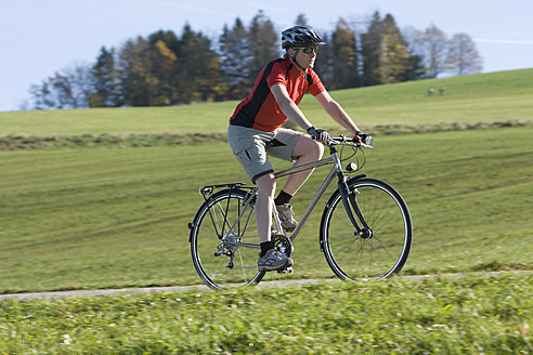Deutschland, Bayern, Älterer Mann fährt Fahrrad - DSF000456