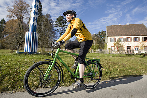 Deutschland, Bayern, Harmating, Älterer Mann fährt Fahrrad - DSF000455