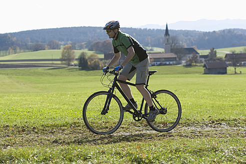 Deutschland, Bayern, Älterer Mann fährt Fahrrad - DSF000453