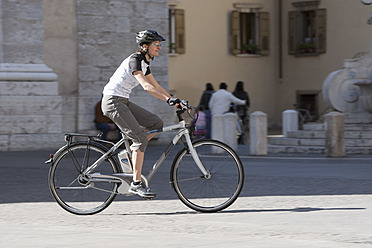 Italien, Arco, Mittlere erwachsene Frau fährt Elektrofahrrad - DSF000444