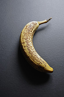 Dunkel gefärbte Banane auf schwarzem Hintergrund, Nahaufnahme - AXF000001