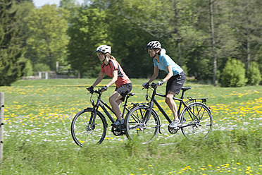 Deutschland, Bayern, Frauen fahren Fahrrad - DSF000537