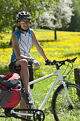 Deutschland, Bayern, Mittlere erwachsene Frau mit Fahrrad, lächelnd - DSF000543