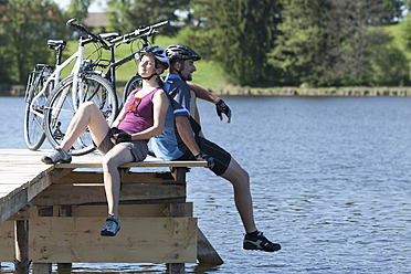 Deutschland, Bayern, Mann und Frau sitzen auf dem Fahrrad - DSF000548