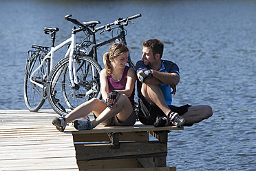 Germany, Bavaria, Man and woman sitting by bicycle - DSF000561