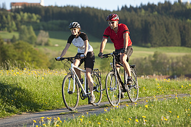 Deutschland, Bayern, Mann und Frau fahren Fahrrad - DSF000557