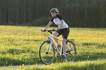 Deutschland, Bayern, Mittlere erwachsene Frau fährt Fahrrad - DSF000551