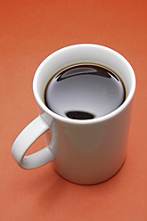 Tasse Kaffee auf orangefarbenem Hintergrund, Nahaufnahme - TCF002322