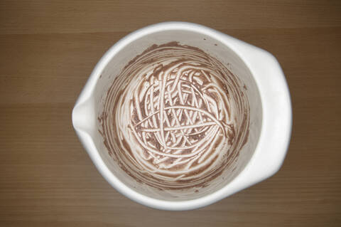Ausgeleckte Schale mit Schokoladenpudding auf Holztisch, Nahaufnahme, lizenzfreies Stockfoto