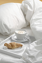 Tablett mit Kaffee, Croissant und Zeitung auf dem Bett - CRF002166