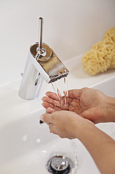 Deutschland, Bayern, Junge Frau beim Händewaschen im Waschbecken - MAEF004593