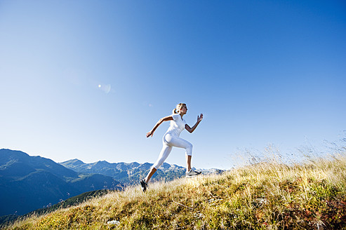 Austria, Salzburg County, Young woman running in alpine meadow - HHF004039