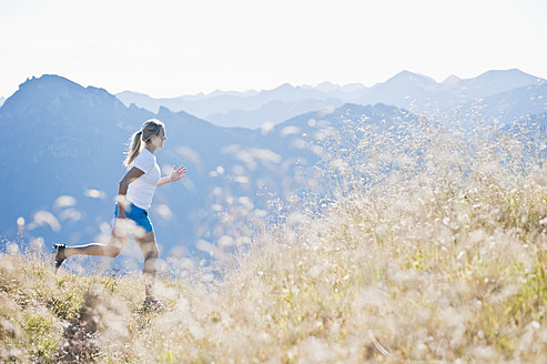 Austria, Salzburg County, Young woman running in alpine meadow - HHF004043