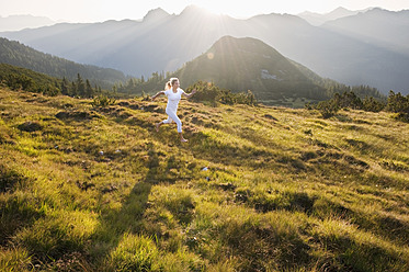 Österreich, Land Salzburg, Junge Frau läuft auf einer Almwiese - HHF004050