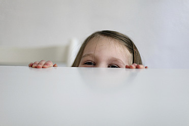 Germany, Berlin, Girl hiding at table - SAF000010