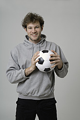 Young man holding soccer ball - TCF002357