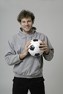 Junger Mann hält Fußball - TCF002357