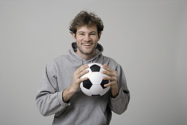 Young man holding soccer ball - TCF002358