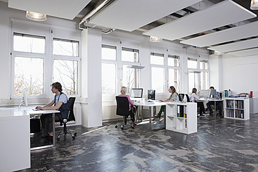 Deutschland, Bayern, München, Männer und Frauen arbeiten am Computer im Büro - RBYF000012