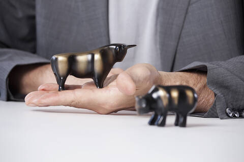 Deutschland, Bayern, München, Älterer Mann mit Stier- und Bärenfiguren, lizenzfreies Stockfoto