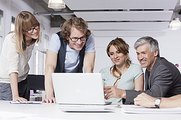 Deutschland, Bayern, München, Männer und Frauen mit Laptop im Büro - RBYF000111