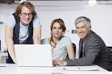 Deutschland, Bayern, München, Mann und Frau mit Laptop im Büro, Portrait - RBYF000112