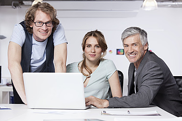 Germany, Bavaria, Munich, Men and woman with laptop in office, portrait - RBYF000112