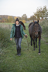 Deutschland, Bayern, Ältere Frau mit Pferd, lächelnd - TCF002425